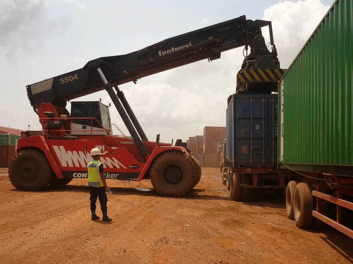 Reach stacker placing a container onto a trailer while a banksman in a hi-vis vest supervises